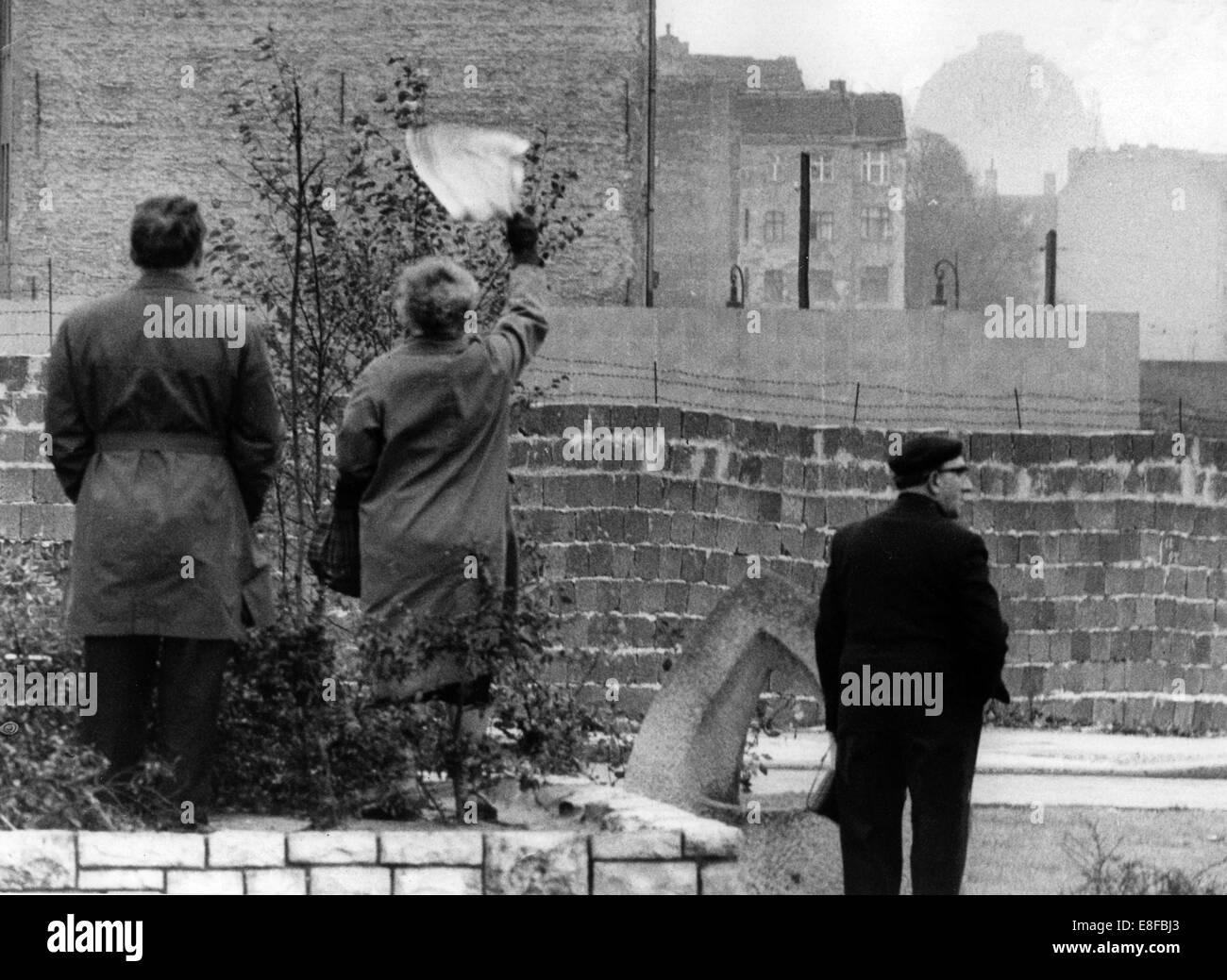 West-Berliner Welle über die Berliner Mauer gegenüber Freunden oder der Familie im östlichen Teil der Stadt am 4. Oktober 1961. Eine Holzwand hinter dem tatsächlichen Steinmauer errichtet behindert Personenansicht voneinander deutlich. Vom 13. August 1961, am Tag des Beginns der Bau der Berliner Mauer, bis 9. November 1989, wurden am Tag des Mauerfalls, den der Bundesrepublik Deutschland und der Deutschen Demokratischen Republik durch den Eisernen Vorhang getrennt. Stockfoto