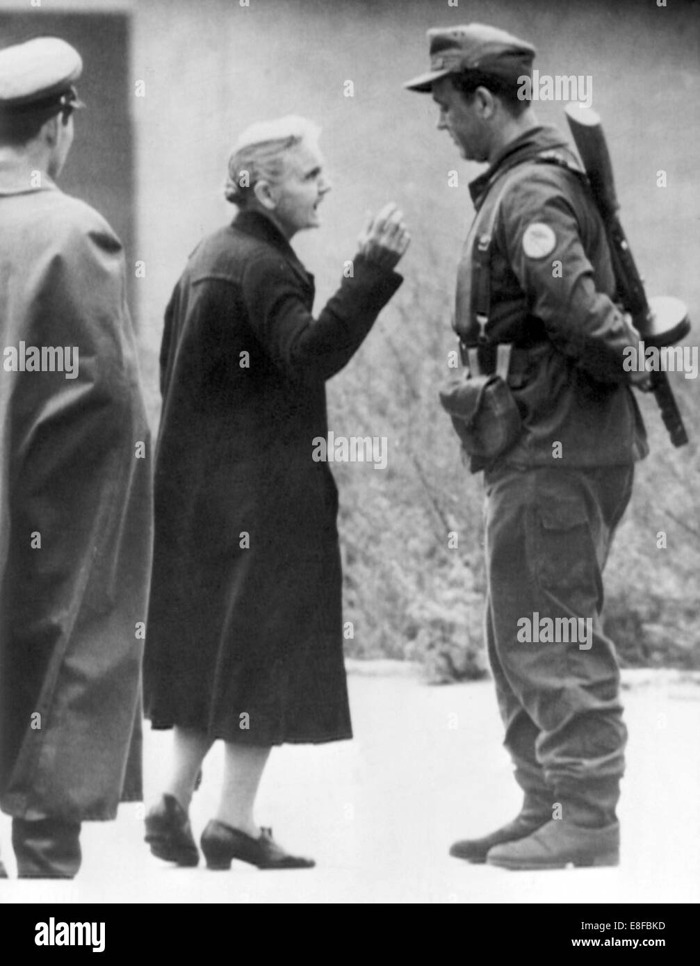 Ein Bürger aus West-Berlin diskutiert aufgeregt mit einem bewaffneten Polizisten die Menschen Polizei an der Grenze-Grenzübergang Erweiterungsset Straße in Kreuzberg am 15. August 1961. Stockfoto