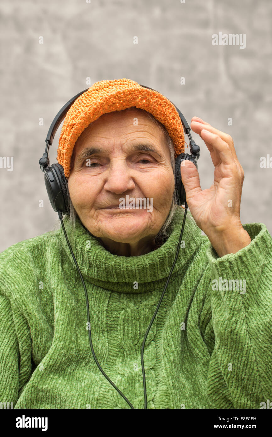 Ältere Frau mit Kopfhörern Musik hören. Stockfoto