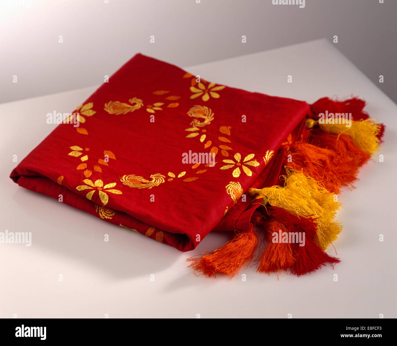 Nahaufnahme von leuchtend roten und orangefarbenen bestickten Schal mit co-Ordinating Quasten Stockfoto