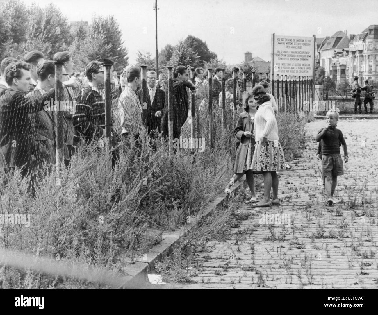 Mehrere Gruppen von Bürgern aus West-Berlin beobachten der Gottvater der Berliner Mauer in einer Straße in Berlin-Neukölln am 13. August 1961. Stockfoto