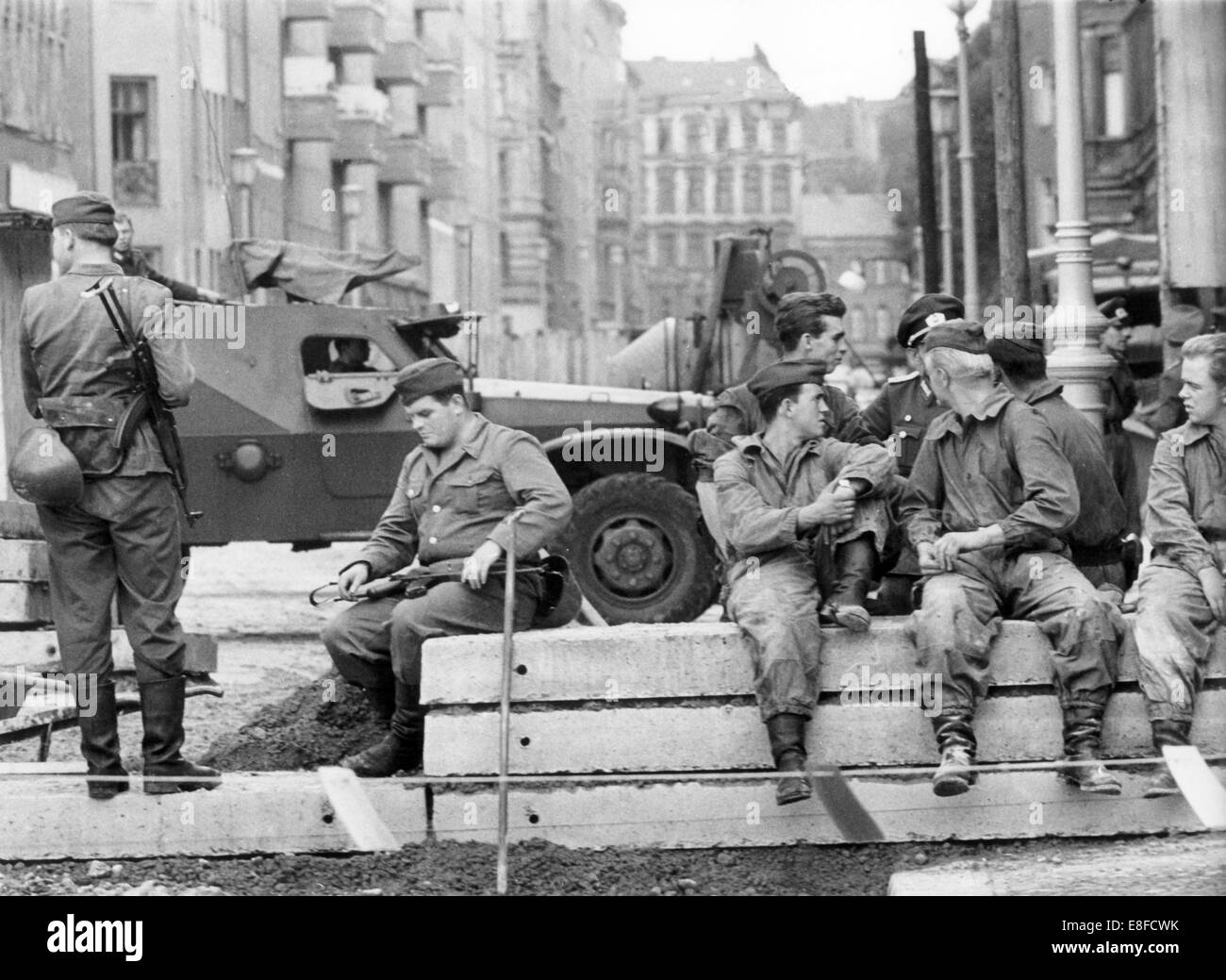 Ein funktionierende Kader von Grenzschutzbeamten aus Ost-Berlin hat eine Pause von der Erneuerung der Berliner Mauer und der Grenzzone in der Bernauer Straße in Berlin, 26. August 1963. 13. August 1961 wurden am Tag des Baus der Berliner Mauer, 9. November 1989, am Tag der Fall der Berliner Mauer, der Bundesrepublik und der DDR durch den Eisernen Vorhang zwischen Ost und West getrennt. Stockfoto