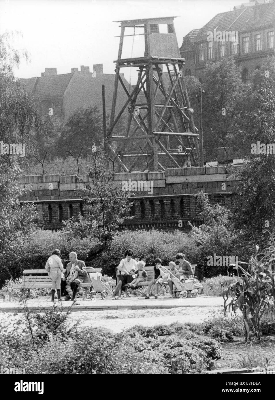 West-Berliner genießen Sie die Sonne in einem Park in Kreuzberg direkt vor der Berliner Mauer und ein Wachturm dahinter, 11. September 1963. 13. August 1961 wurden am Tag des Baus der Berliner Mauer bis zum Fall der Berliner Mauer am 9. November 1989, der Bundesrepublik und der DDR durch den Eisernen Vorhang zwischen Ost und West getrennt. Stockfoto