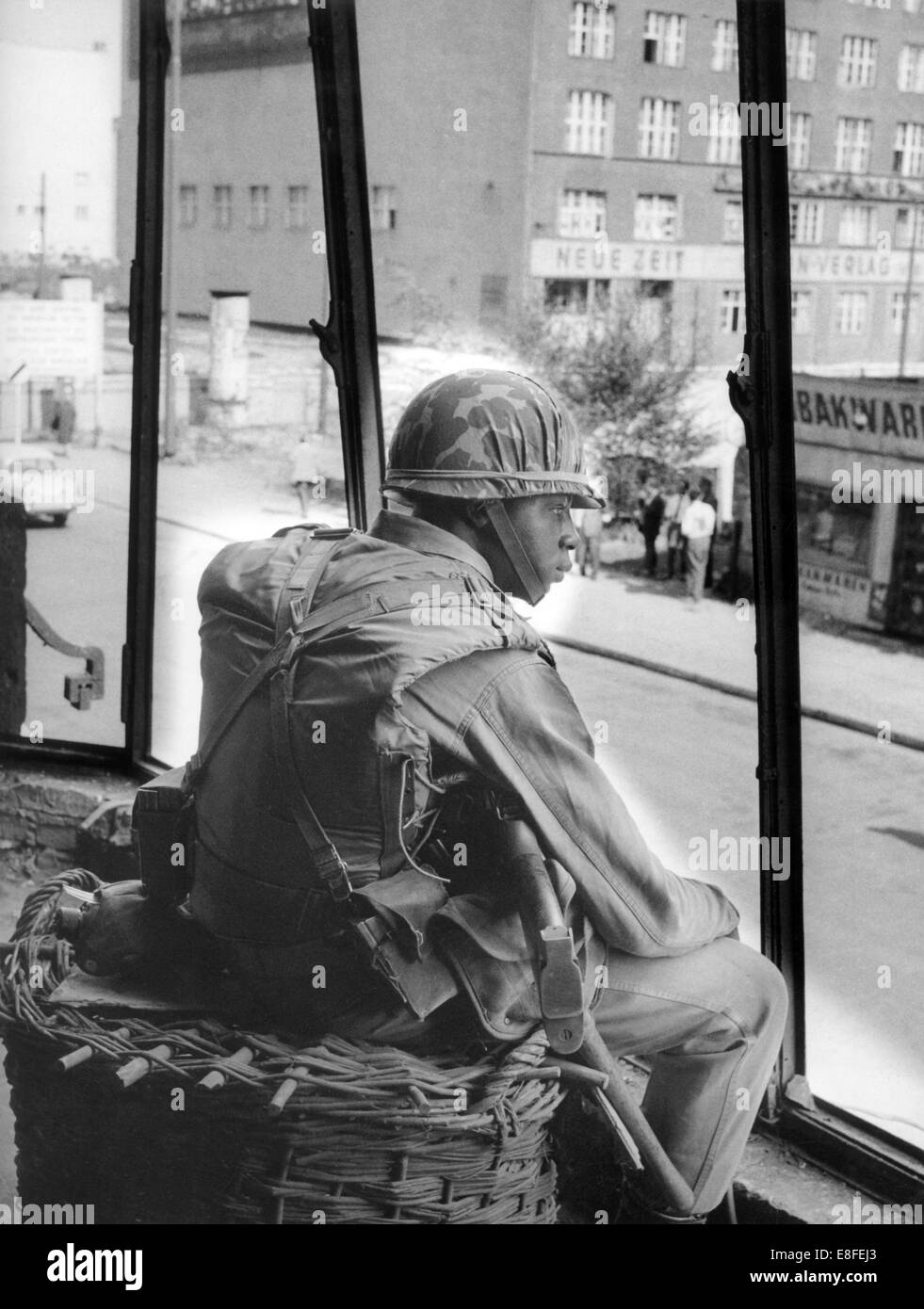 Ein Soldat der US Army sitzt in einer Ruine auf der Friedrichstraße in West-Berlin und beobachten Sie hält an der Sektor-Grenze in den östlichen Teil der Stadt am 29. August 1961. Vom 13. August 1961, der Tag der Errichtung der Mauer, waren bis zum Fall der Berliner Mauer am 9. November 1989 der Bundesrepublik und der DDR durch den "Eisernen Vorhang" zwischen Ost und West getrennt. Stockfoto