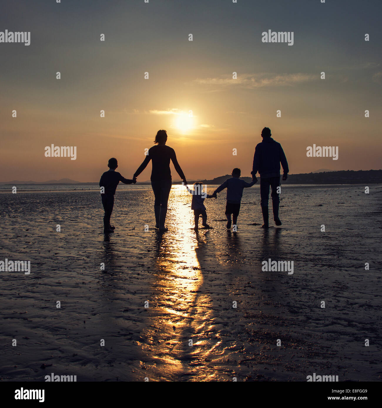 Silhouette einer Familie am Strand Hand in Hand Stockfoto