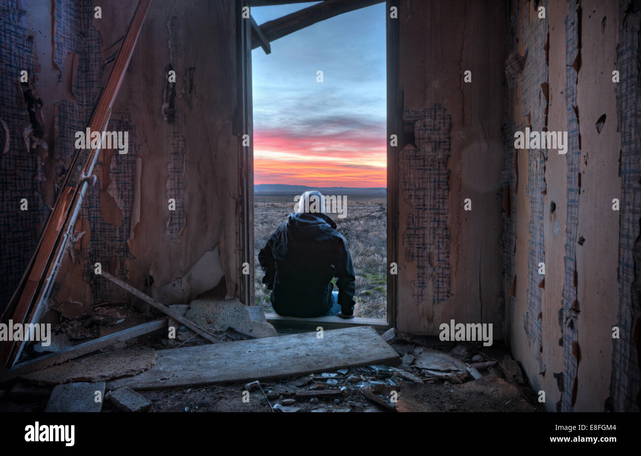 USA, Idaho, Rückansicht der Mann sitzt auf Tür Blick auf Sonnenuntergang Stockfoto