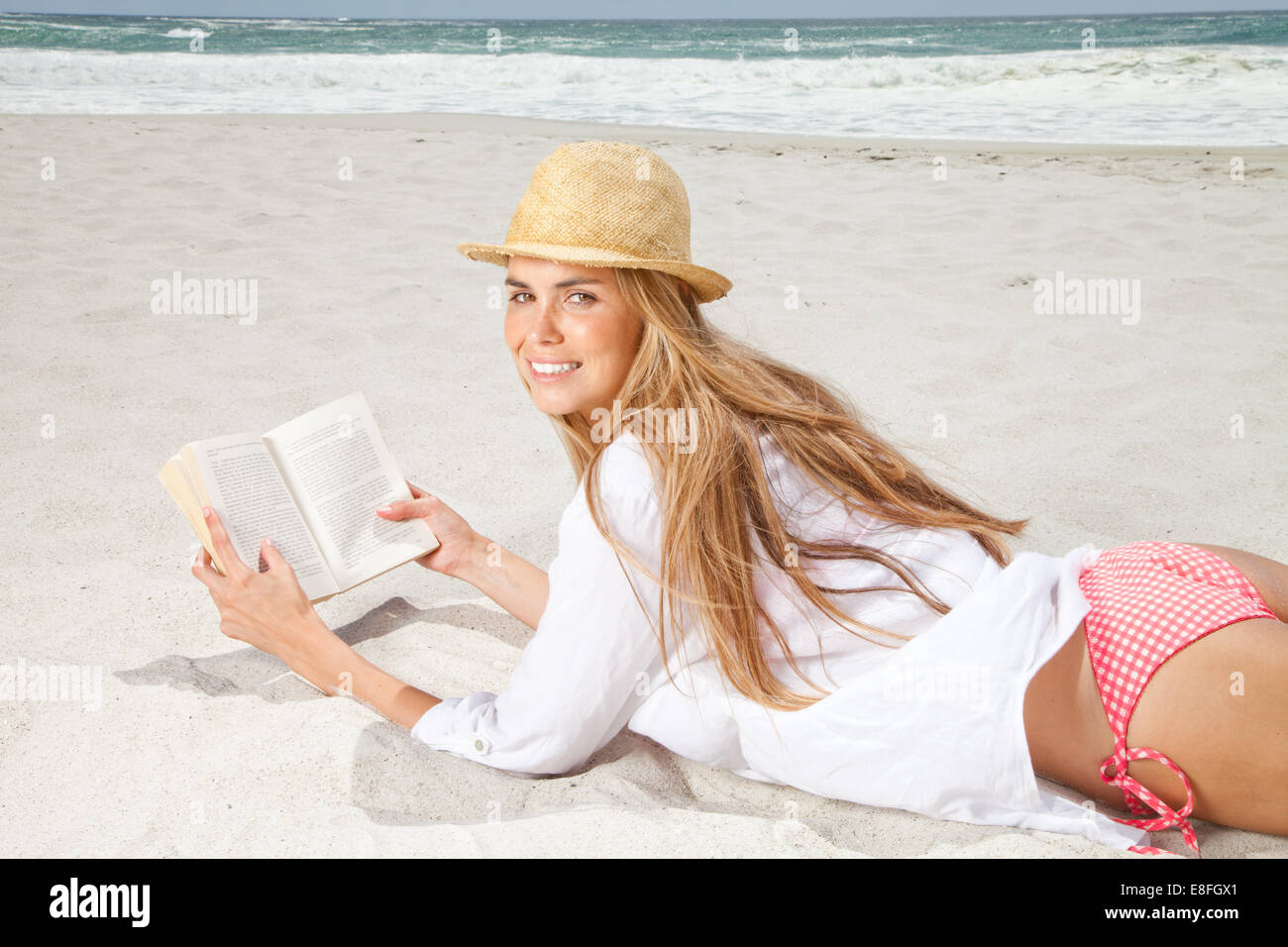 Frau, die am Strand liegt und ein Buch liest, Kapstadt, Westkap, Südafrika Stockfoto