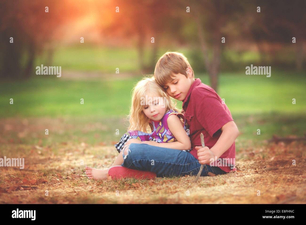 Junge und ein Mädchen sitzen in einem Park spielen, Kalifornien, USA Stockfoto