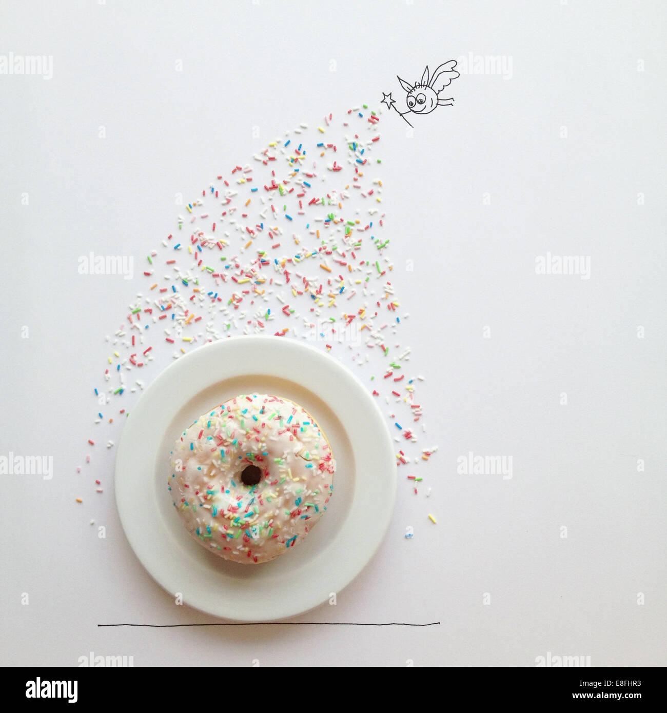 Konzeptionelle Fee einen Donut mit Streuseln dekorieren Stockfoto