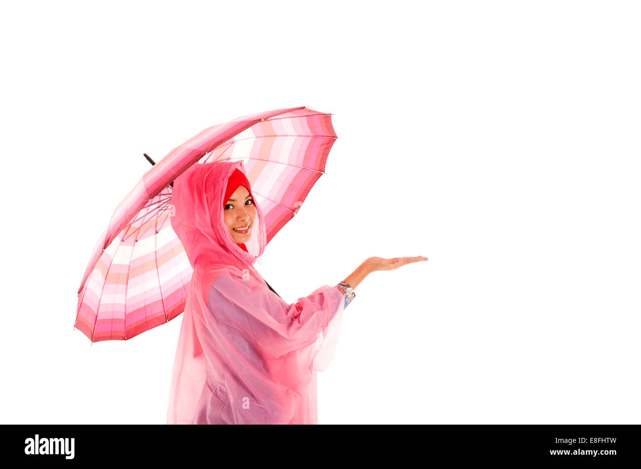 Porträt eines lächelnden muslimischen Teenagers, das einen Regenschirm hält Stockfoto
