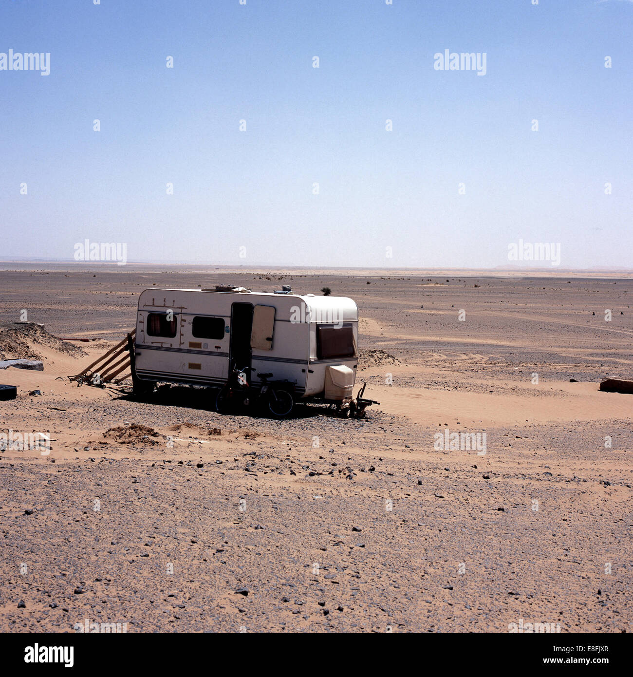 Fahrrad vor einem Wohnwagen in der Wüste, Marokko geparkt Stockfoto