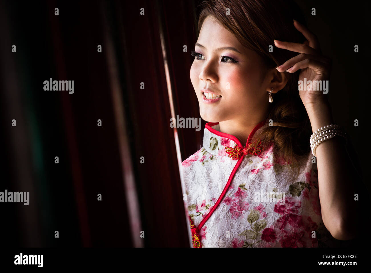 Porträt der jungen Frau aus Fenster Stockfoto
