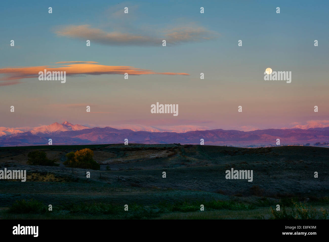 Mond-Einstellung und Sonnenaufgang über dem felsigen Berge Stockfoto