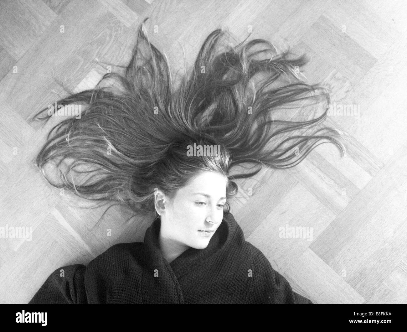 Mädchen, die auf hölzernen Stock With Her Hair liegend ausbreiten Stockfoto