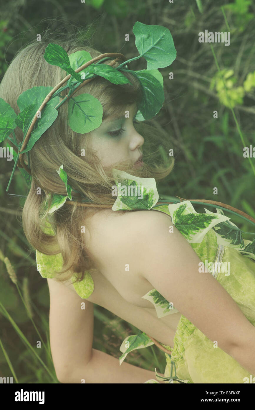 Mädchen im Wald stehend als Baumfee gekleidet Stockfoto