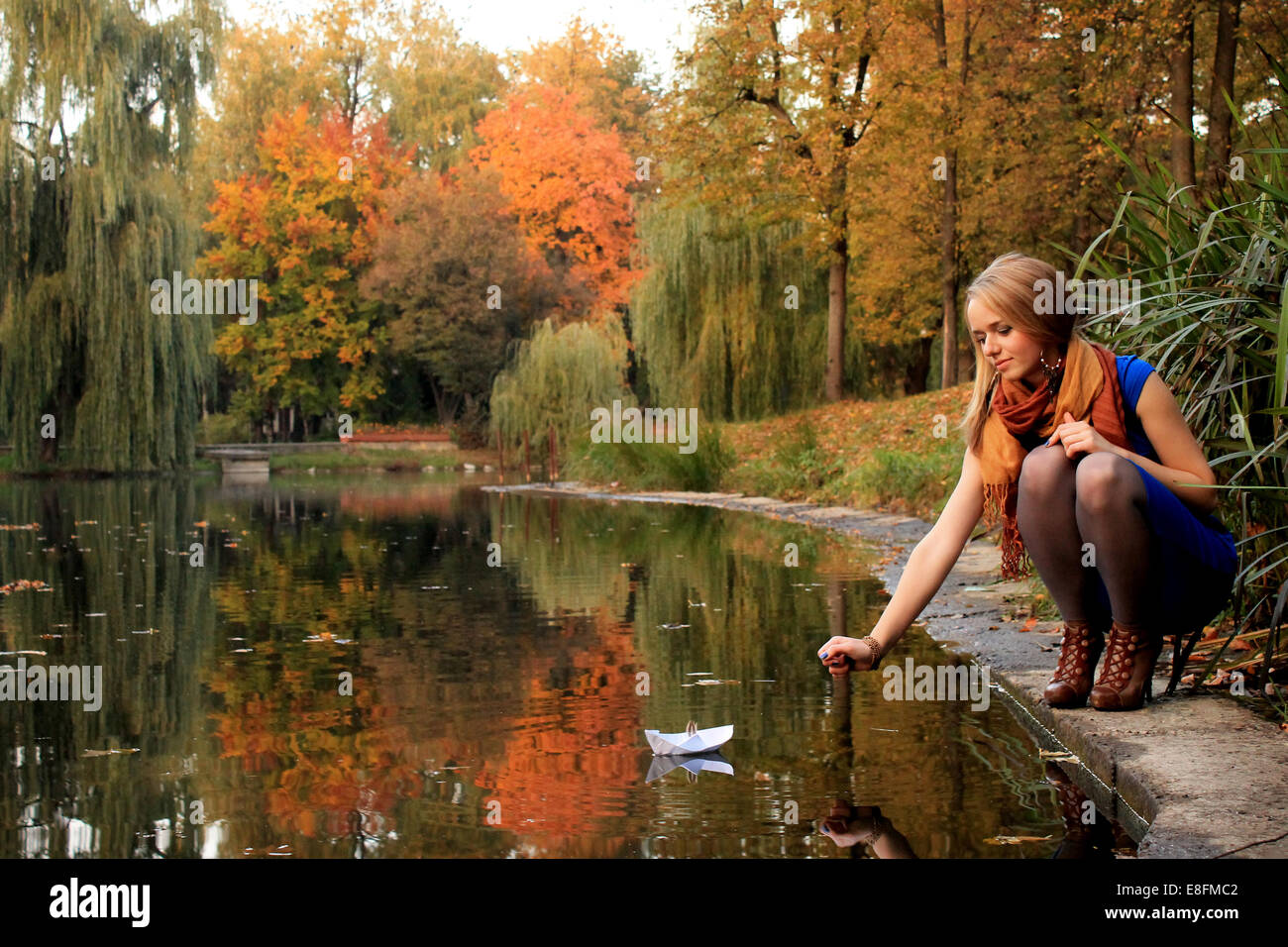 Junge Frau mit Papier Schiff im park Stockfoto