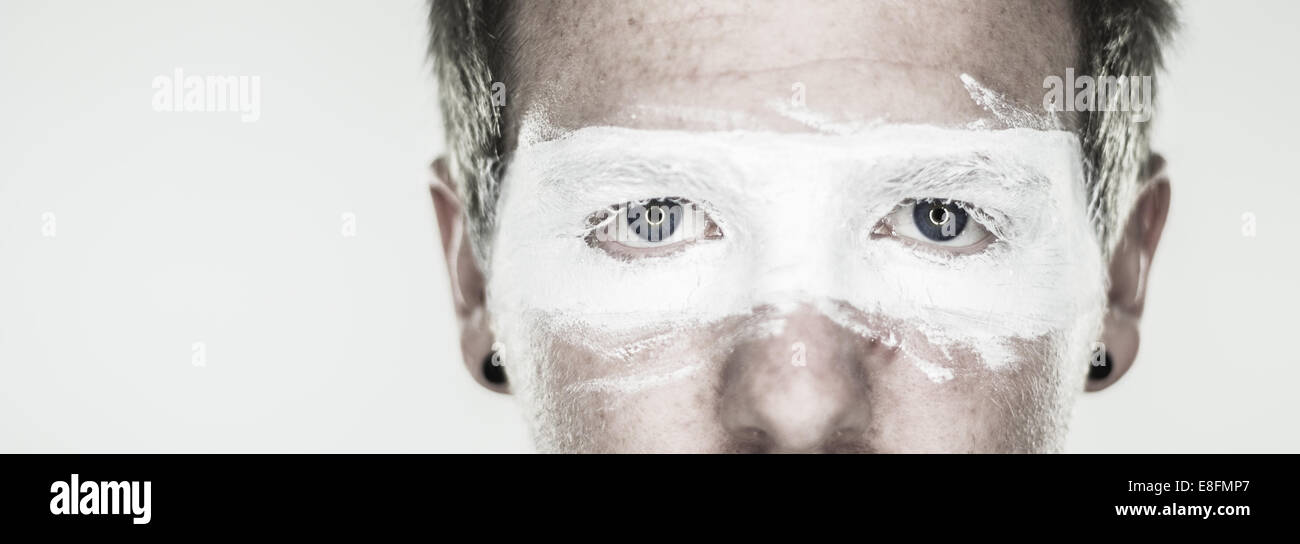 Porträt eines Mannes Gesicht mit einer bemalten Maske, die seine Augen bedeckt Stockfoto