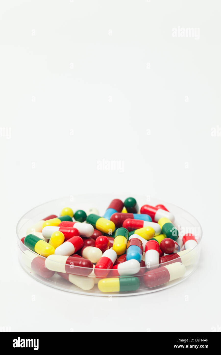 Nahaufnahme einer transparenten Petrischale, gefüllt mit bunten Pillen Stockfoto