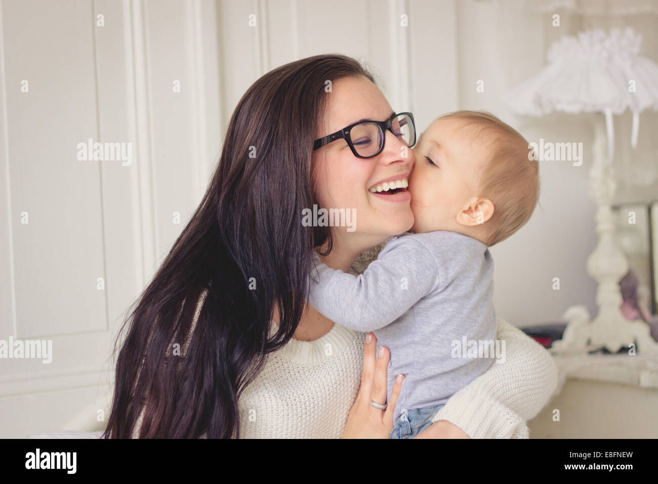 Lächelnde Mutter kuschelt ihren kleinen Jungen Stockfoto