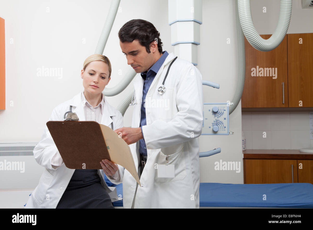 Zwei Ärzte medizinische Hinweise im Krankenhaus Untersuchungsraum betrachten Stockfoto