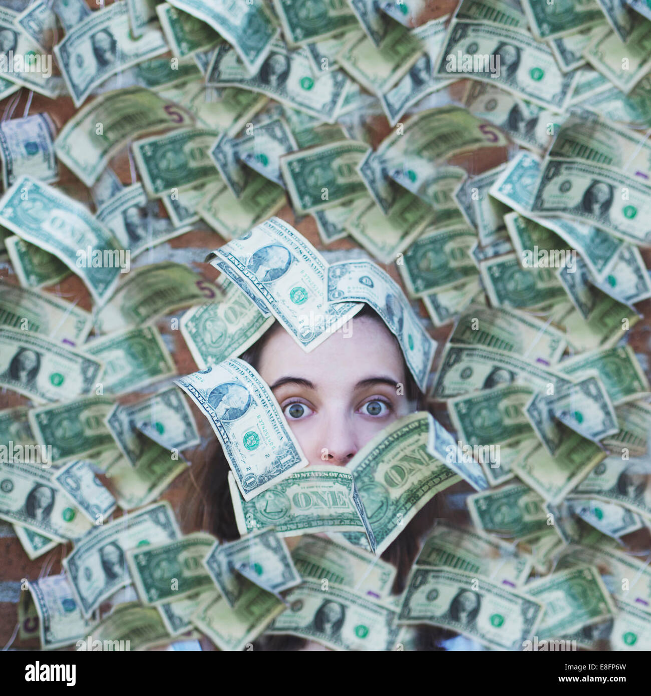 Porträt einer Frau in US-Dollar-Rechnungen begraben Stockfoto