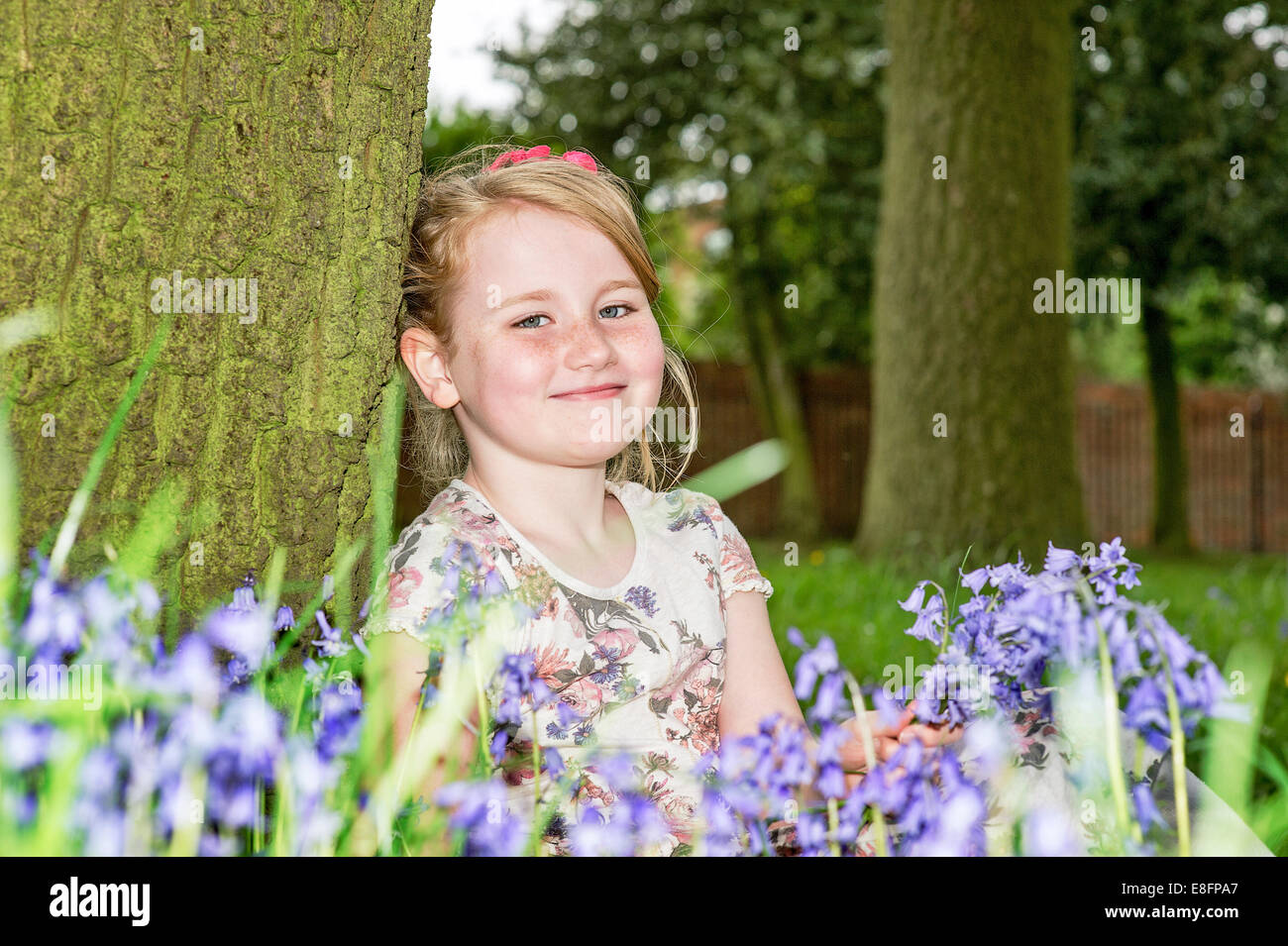 Vereinigtes Königreich, UK, West Midlands, Warwickshire, Rugby, Portrait eines Mädchens (8-9) lächelnd unter Blumen Stockfoto