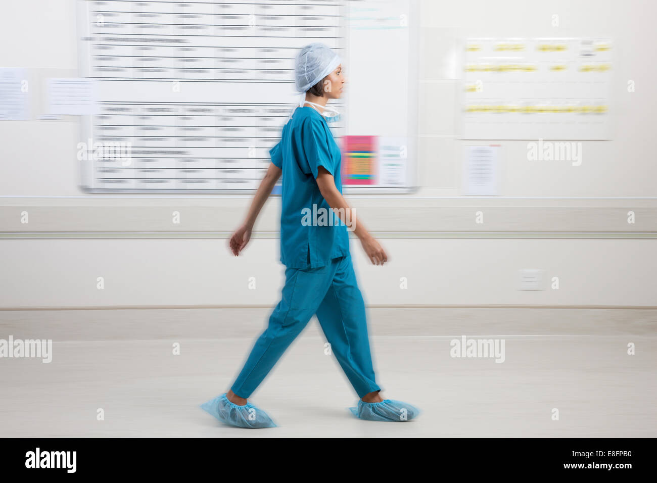 Chirurg, vorbei an Zeitplan Board im Krankenhaus Stockfoto