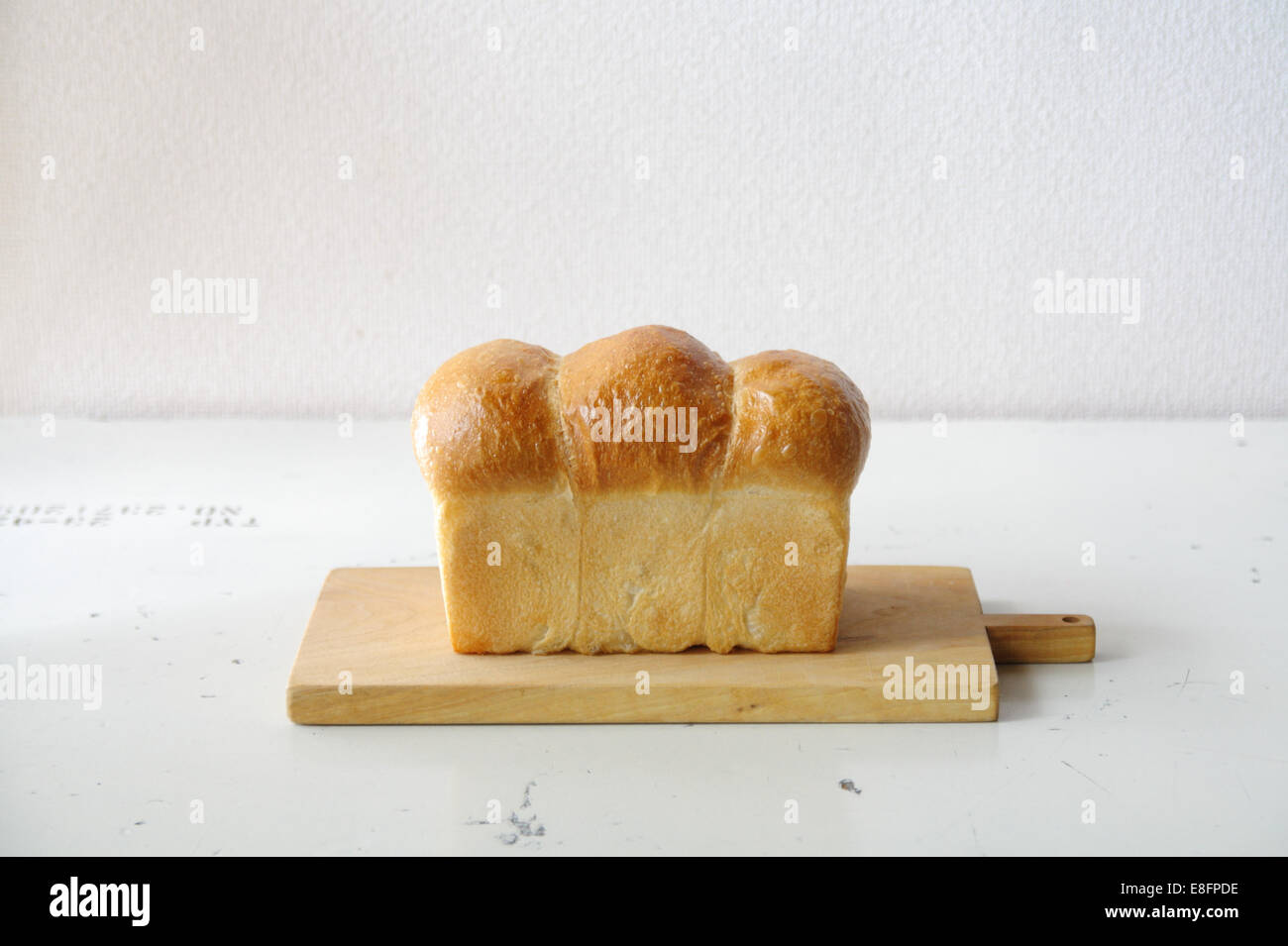 Laib Brot auf Schneidebrett Stockfoto