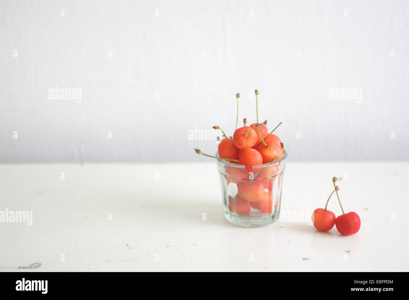 Ein Glas Kirschen auf einem Holztisch Stockfoto