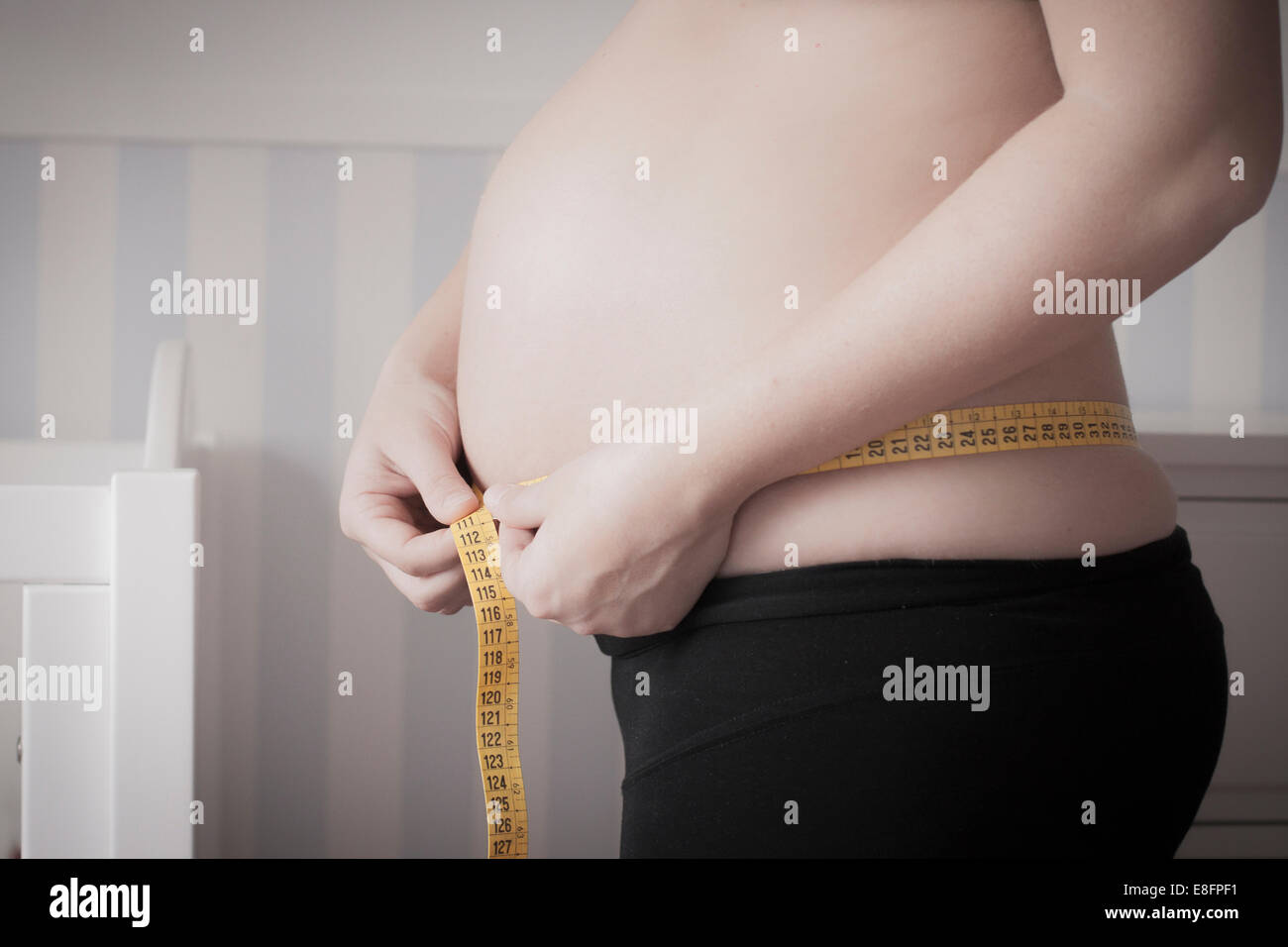 Schwangere Frau ihren Bauch messen Stockfoto