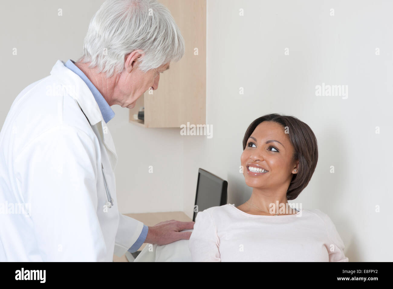 Arzt im Gespräch mit der Patientin im Untersuchungsraum Stockfoto