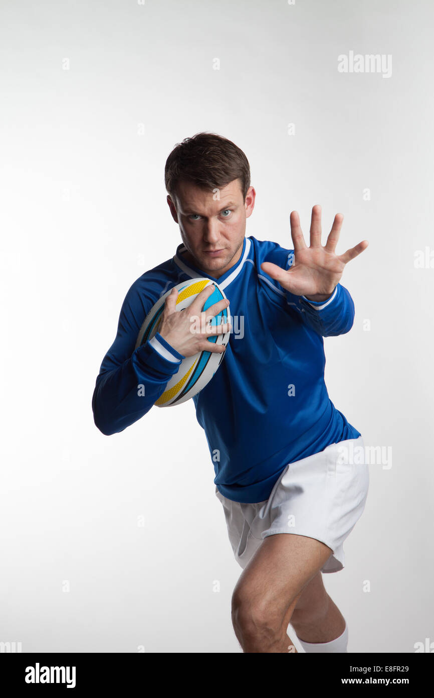 Rugby-Spieler laufen mit Rugby-ball Stockfoto