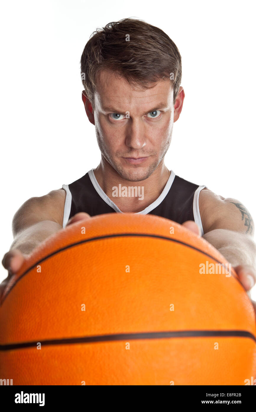 Basketballspieler, der Basketball vor sich hält Stockfoto