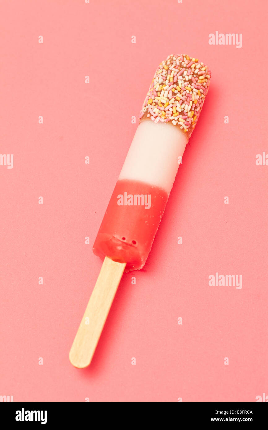 Ice Lolly mit Streuseln auf einem rosa Hintergrund Stockfoto