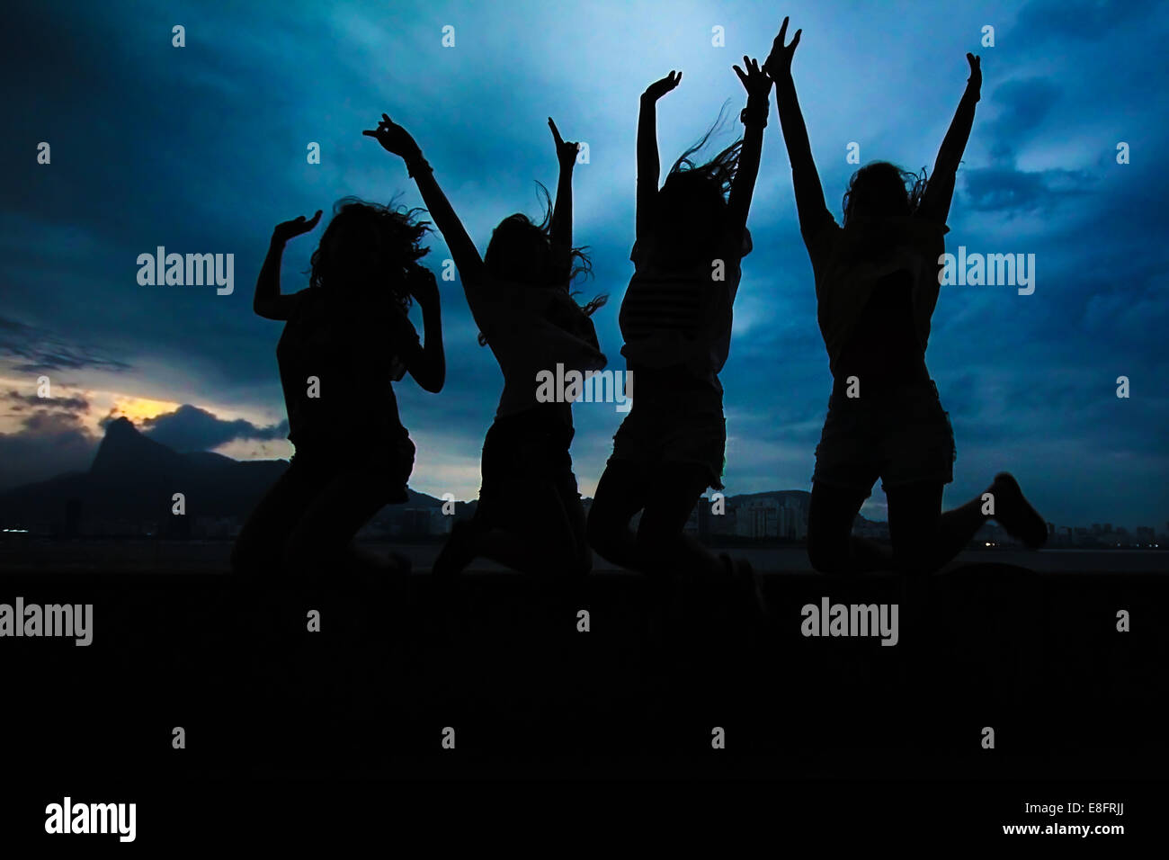 Silhouette von vier Frauen, die in die Luft springen Stockfoto