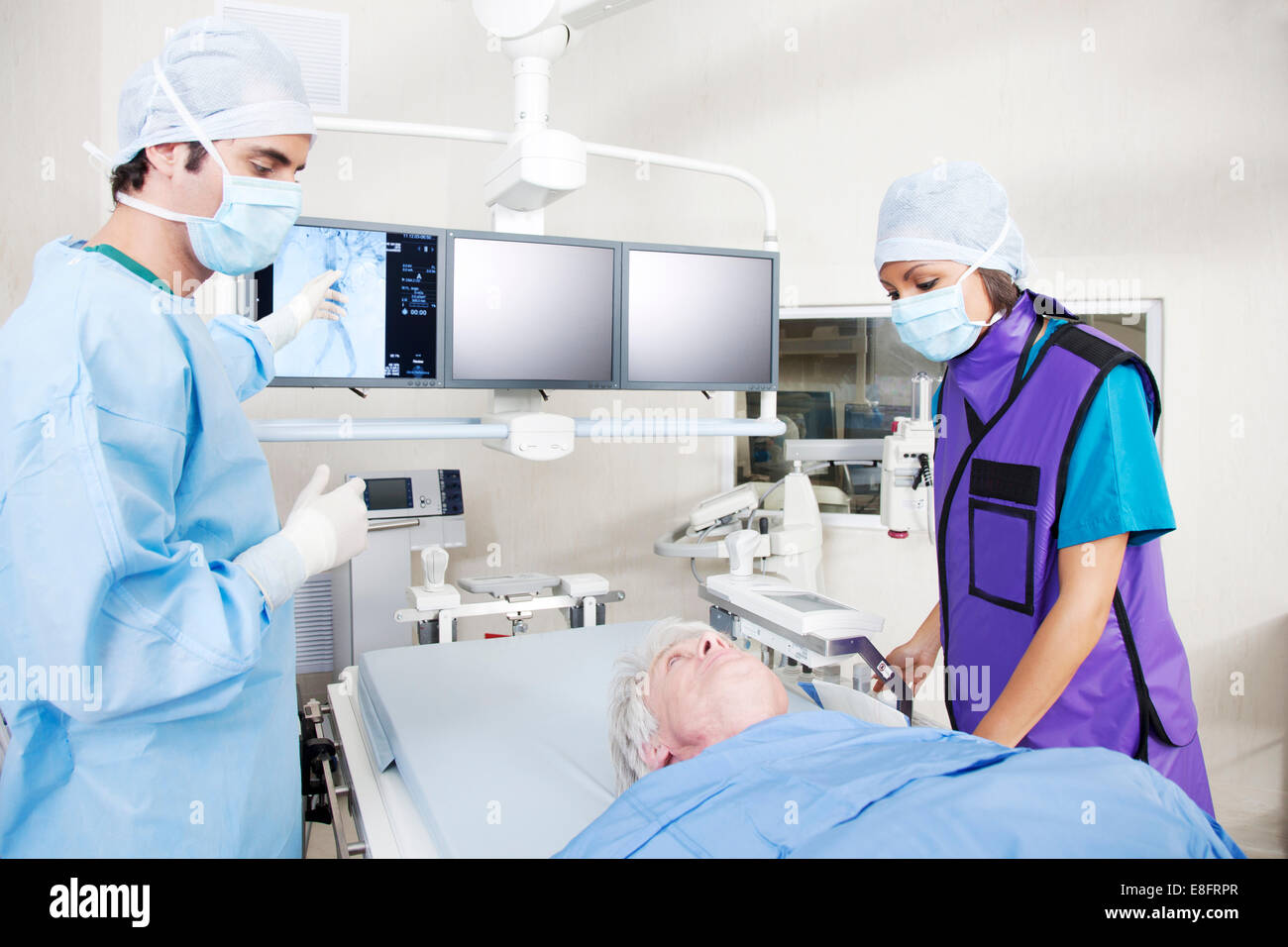 Arzt und Krankenschwester Analyse MRI scan mit Patienten im OP-Saal Stockfoto