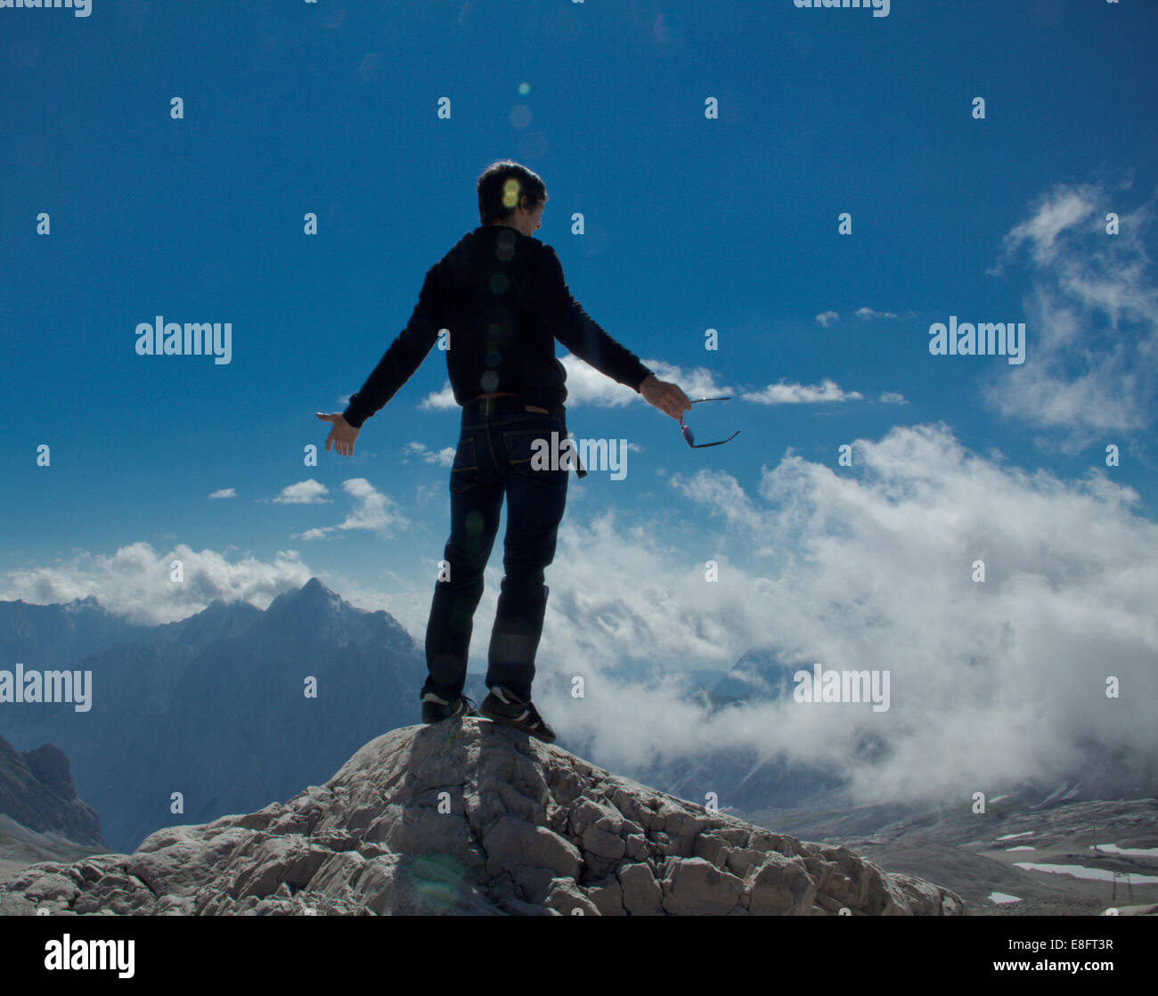 Mann steht auf dem Gipfel eines Berges Stockfoto