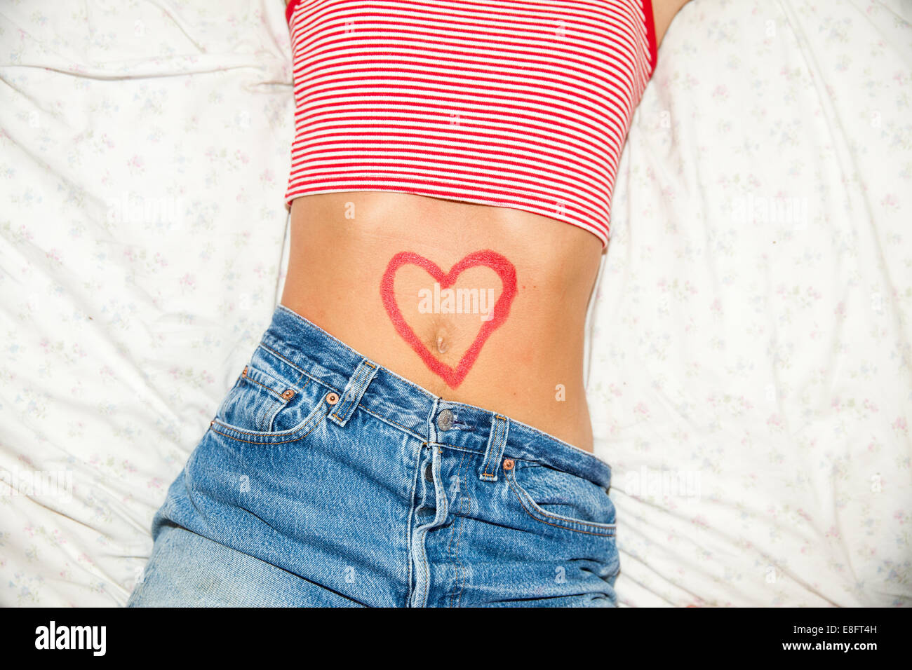 Herzförmige Zeichnung auf dem Bauch einer Frau Stockfoto