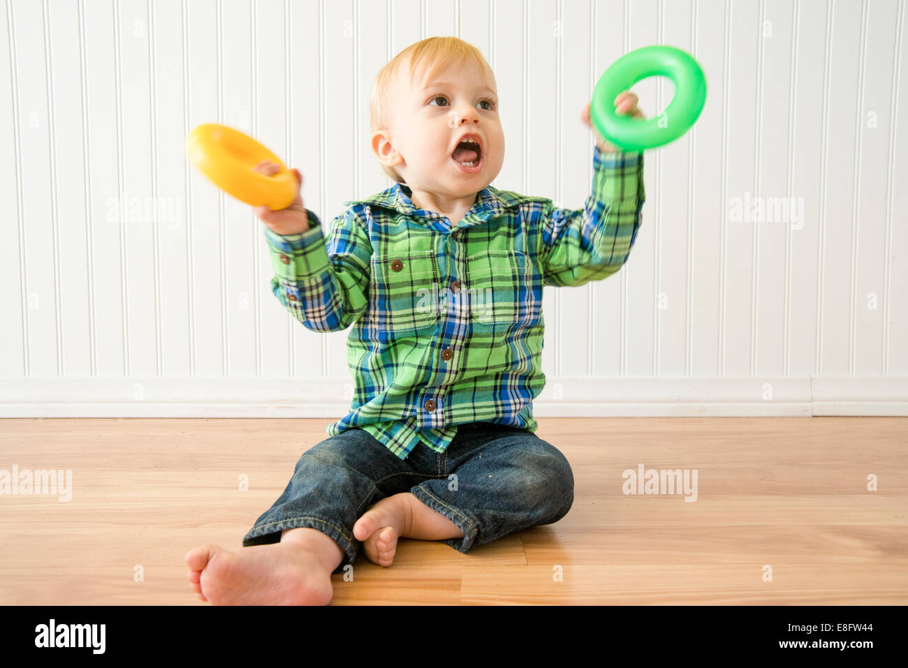 Jungen (12-17 Monate) spielt mit Kunststoff-Ringe Stockfoto