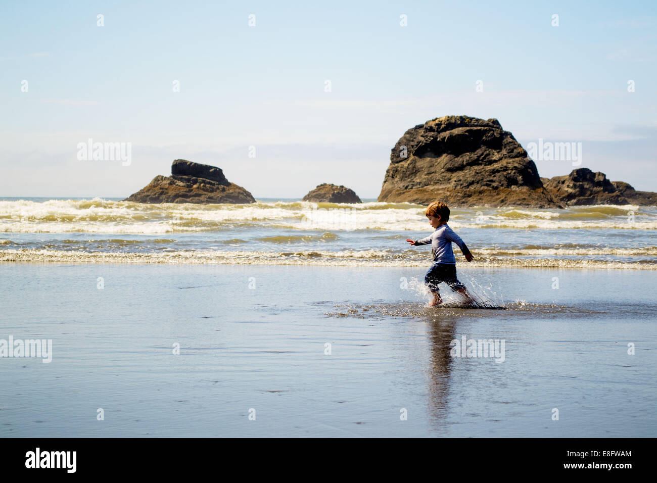 Junge, die am Strand in den Untiefen, USA laufen Stockfoto