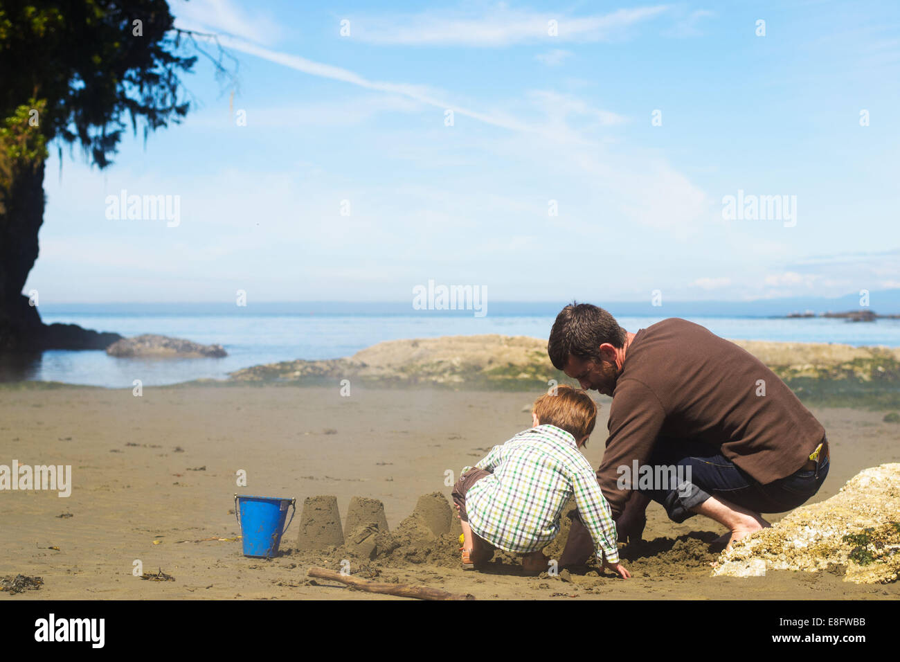 Vater und Sohn bauen eine Sandburg am Strand, USA Stockfoto