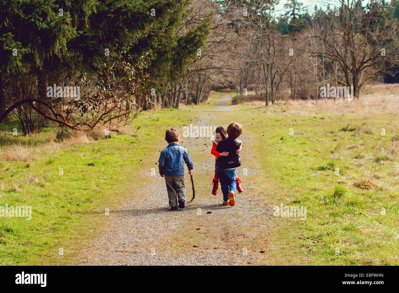 Drei Kinder spielen auf einem ländlichen Fußweg, USA Stockfoto