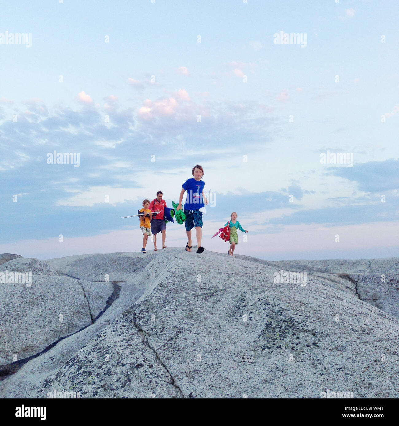 Vater von drei Kindern, die zu Fuß über Felsen, Norwegen Stockfoto