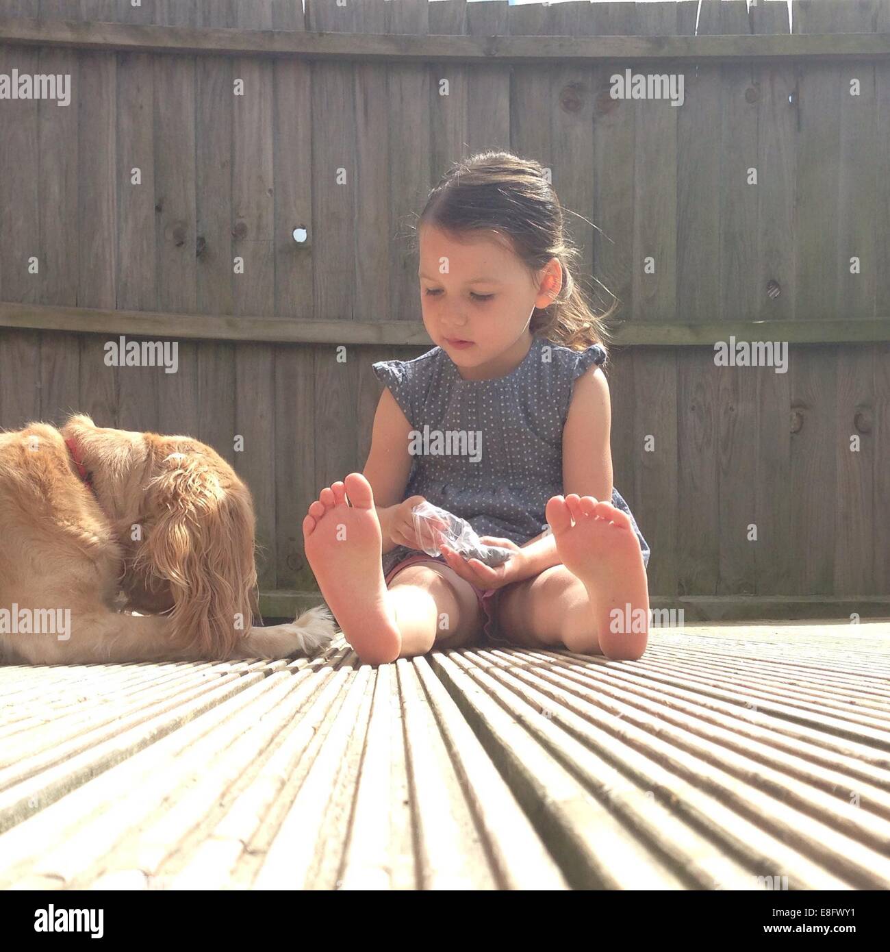Mädchen sitzen auf der Terrasse mit ihrem Hund Stockfoto