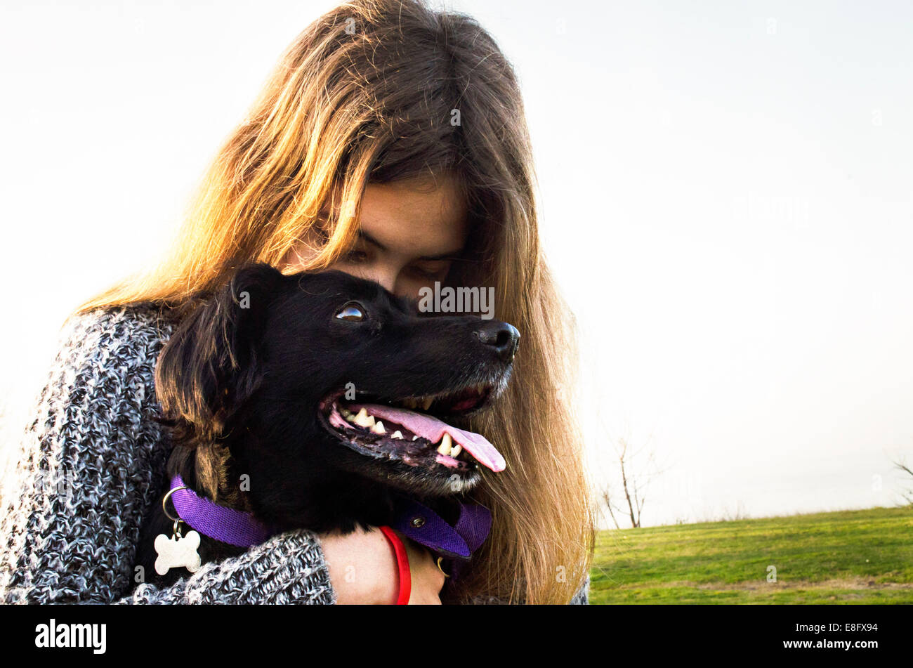 Argentinien, Buenos Aires, Blick auf Teenager-Mädchen (14-15 Jahre) umarmt Hund Stockfoto