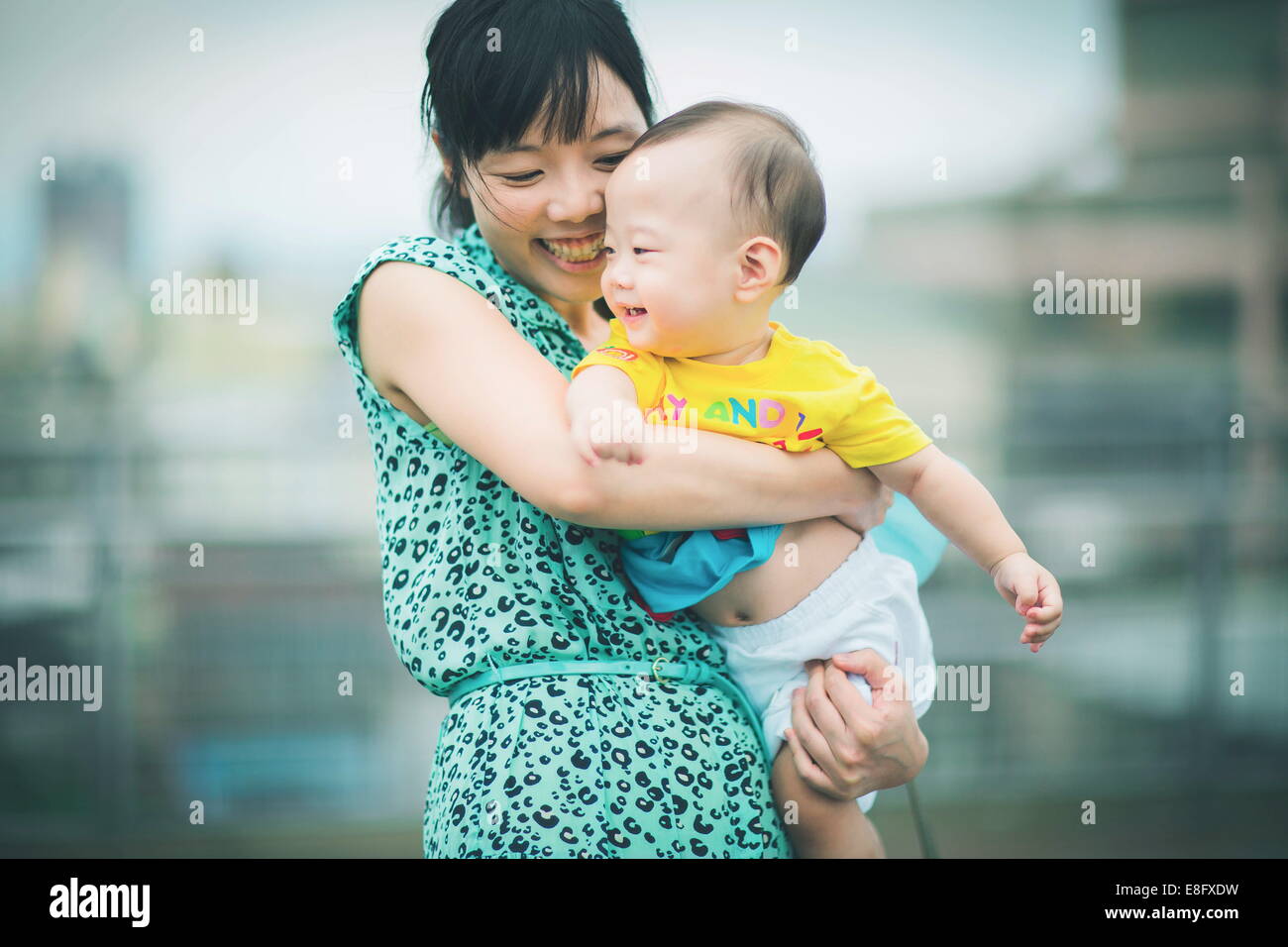 Porträt einer Mutter, die ihren Sohn beim Tanzen hält Stockfoto