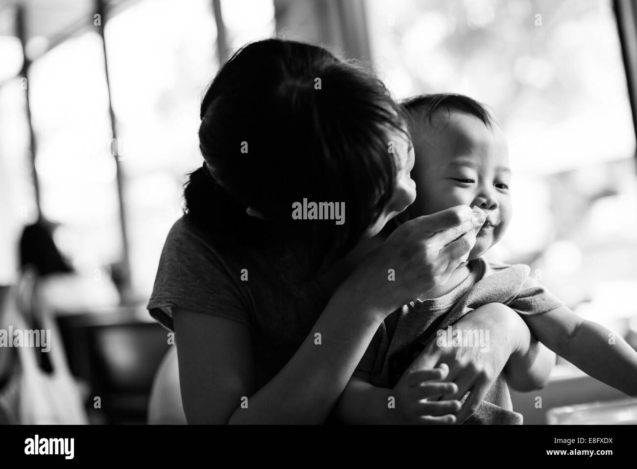 Porträt einer Mutter, die den Mund ihres Sohnes wischt Stockfoto