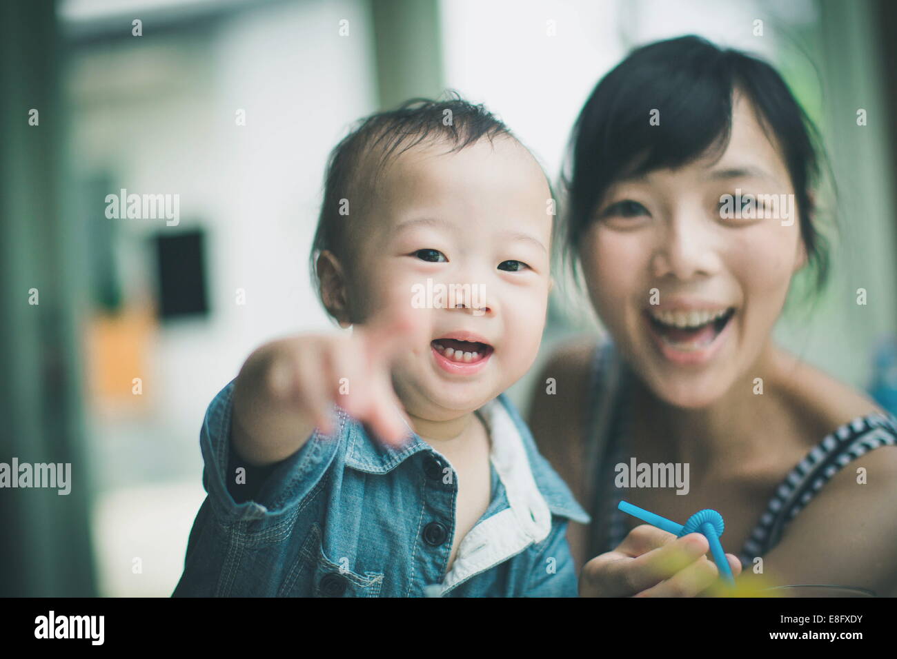 Porträt einer glücklichen Mutter, die schaut, wohin ihr Sohn zeigt Stockfoto