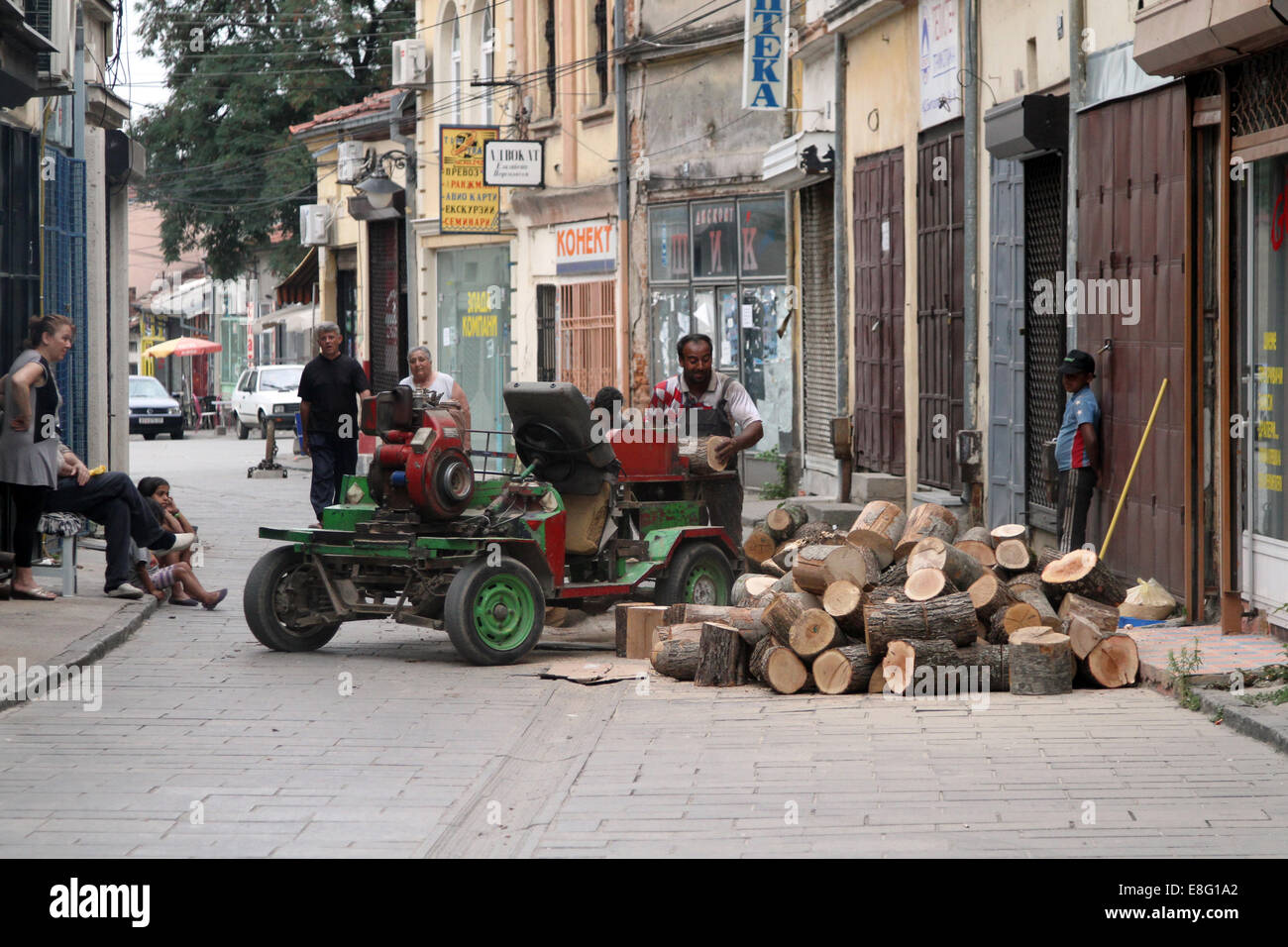 Ein Mann mit einer tragbaren zieht eine kleine Schar von Schaulustigen auf den Straßen von Bitola, Mazedonien Stockfoto