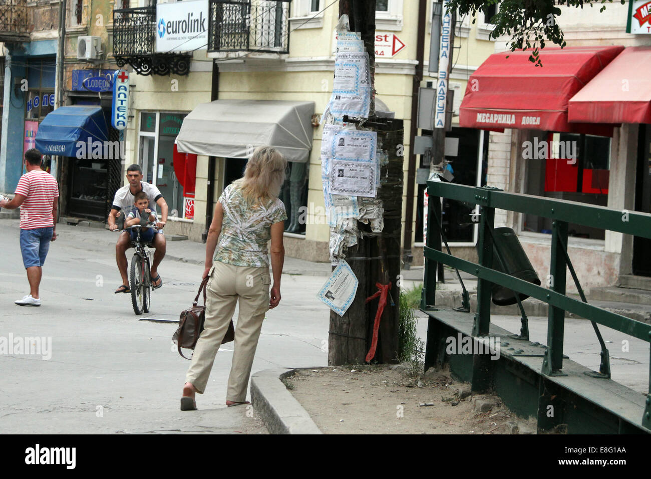 Eine Frau untersucht Beerdigung Bekanntmachungen veröffentlicht auf einem Baum in Bitola, Mazedonien Stockfoto
